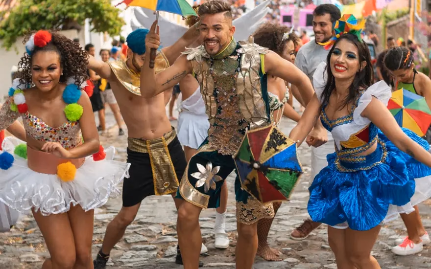 Grupo fantasiado dançando em bloco de rua durante o Carnaval