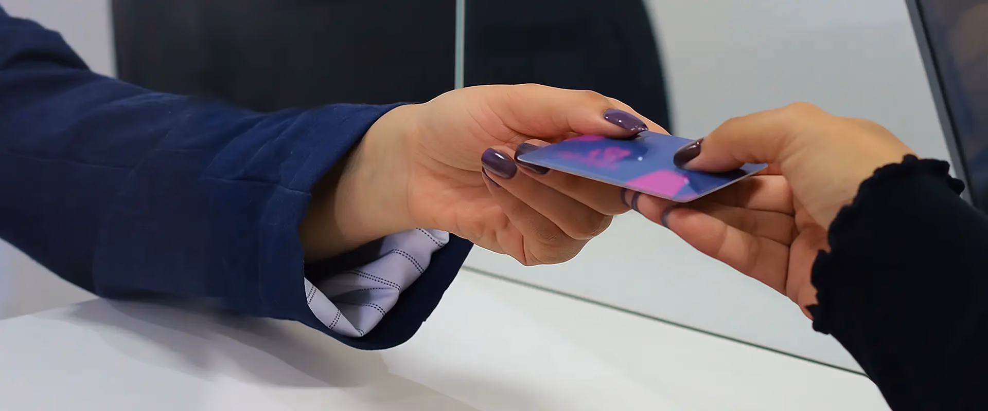 Recepcionista da Med Anchieta entregando o Cartão Saúde Anchieta a uma cliente