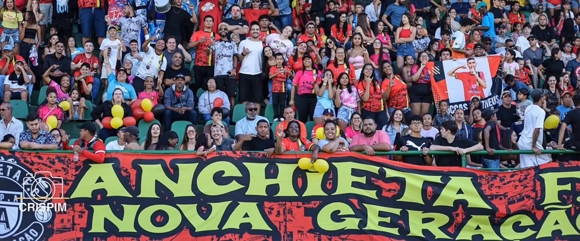 Torcida em arquibancada com a faixa "Anchieta Nova Geração", em evento apoiado pela Med Anchieta