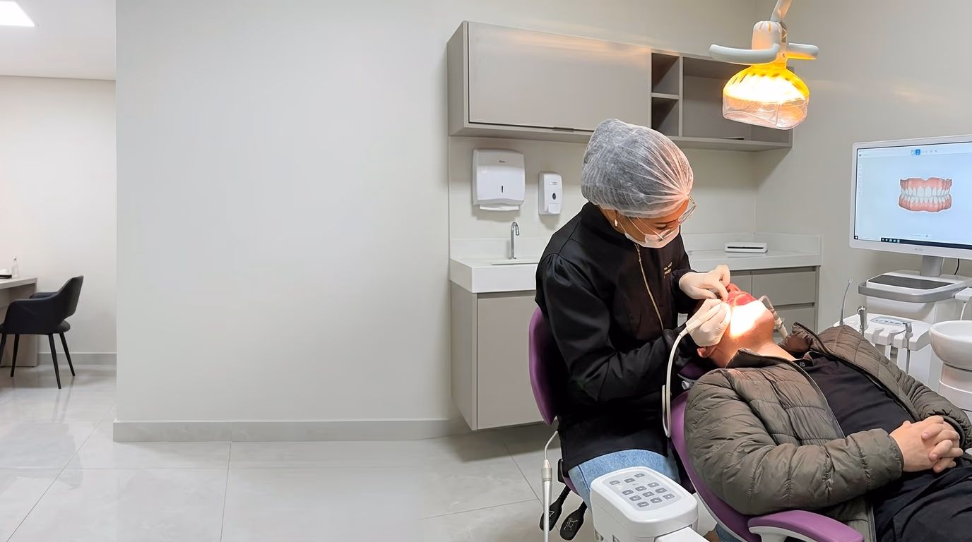 Dentista da Med Anchieta atendendo um paciente no consultório