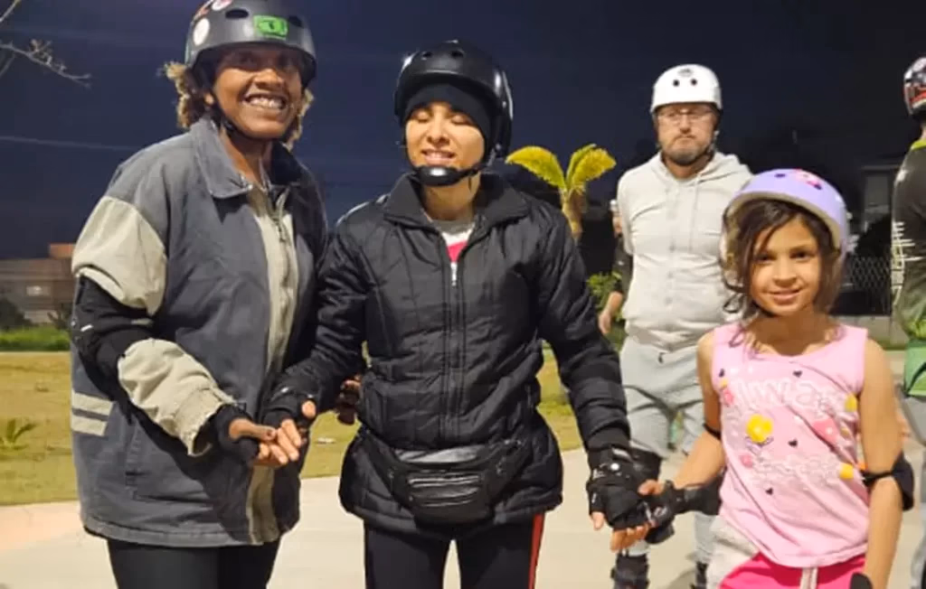 Tio Ricardo com duas crianças de capacete durante uma sessão do Loucos por Patins